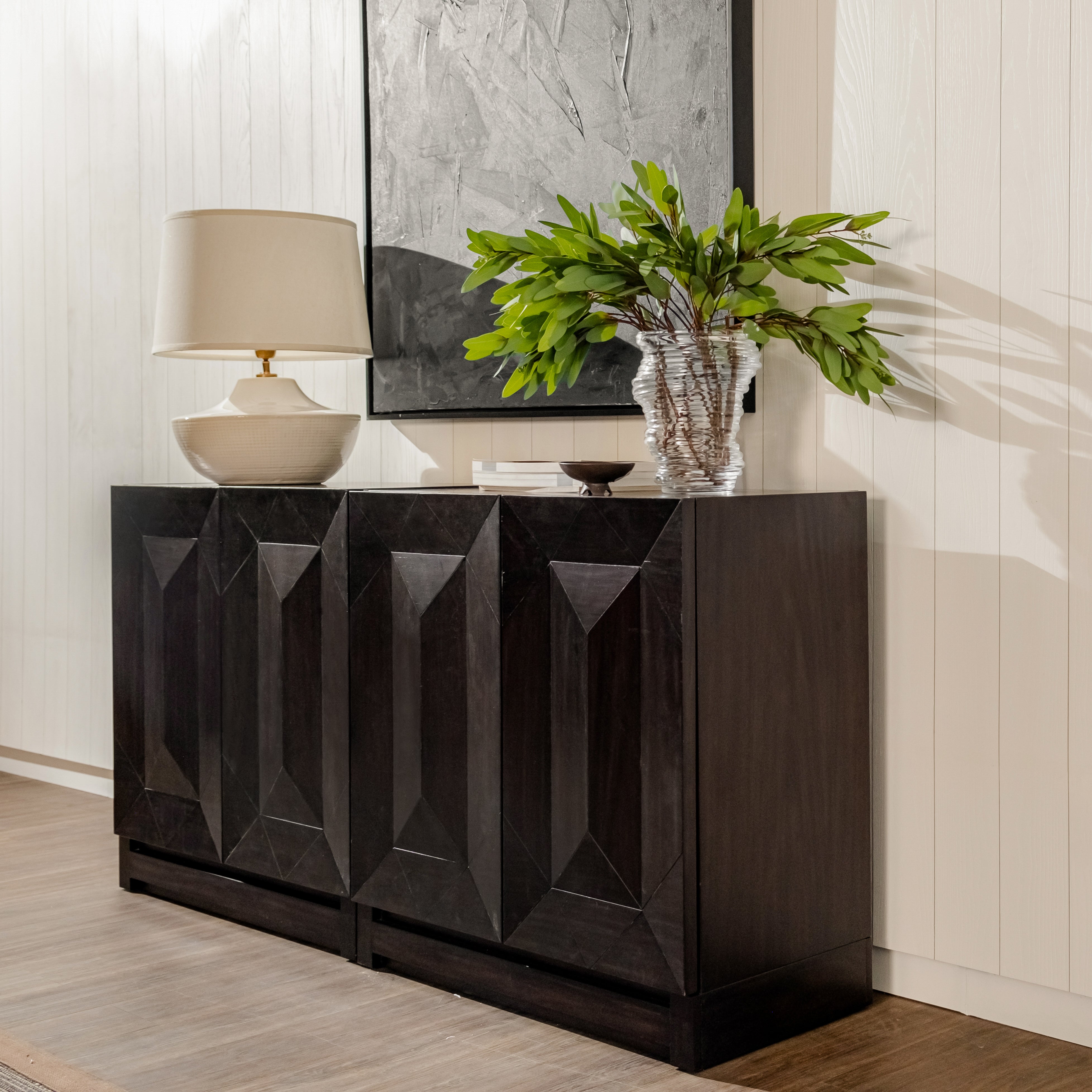 Black Averi Modular Cabinet with decorative items including a lamp, plant, and abstract painting in a room.