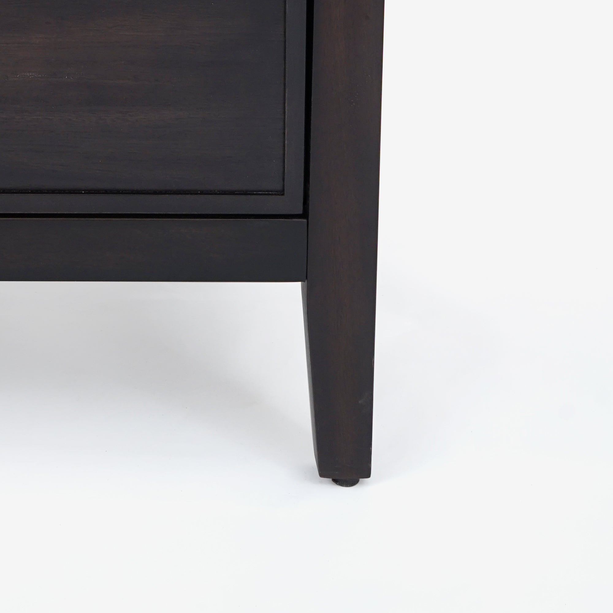 Close-up of a dark wooden leg on a piece of furniture