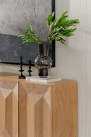 Decorative setup with a vase and plant on a Natural Averi Modular Cabinet against a tiled wall.
