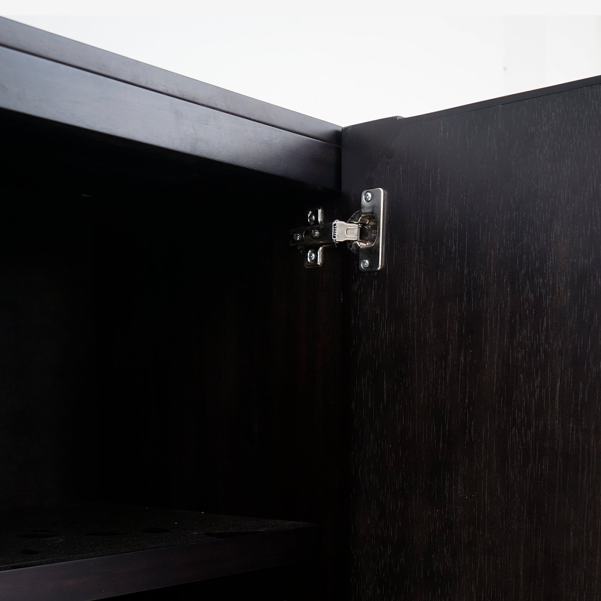 Close-up of a black cabinet door with a visible hinge
