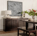 Dining room with dark wood sideboard, table, and decorative elements.