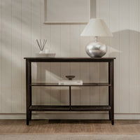 Wooden console table with decorative items against a neutral wall.
