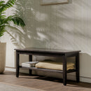 Wooden bench with folded towels against a light wooden paneled wall.