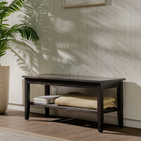 Wooden bench with folded towels against a light wooden paneled wall.