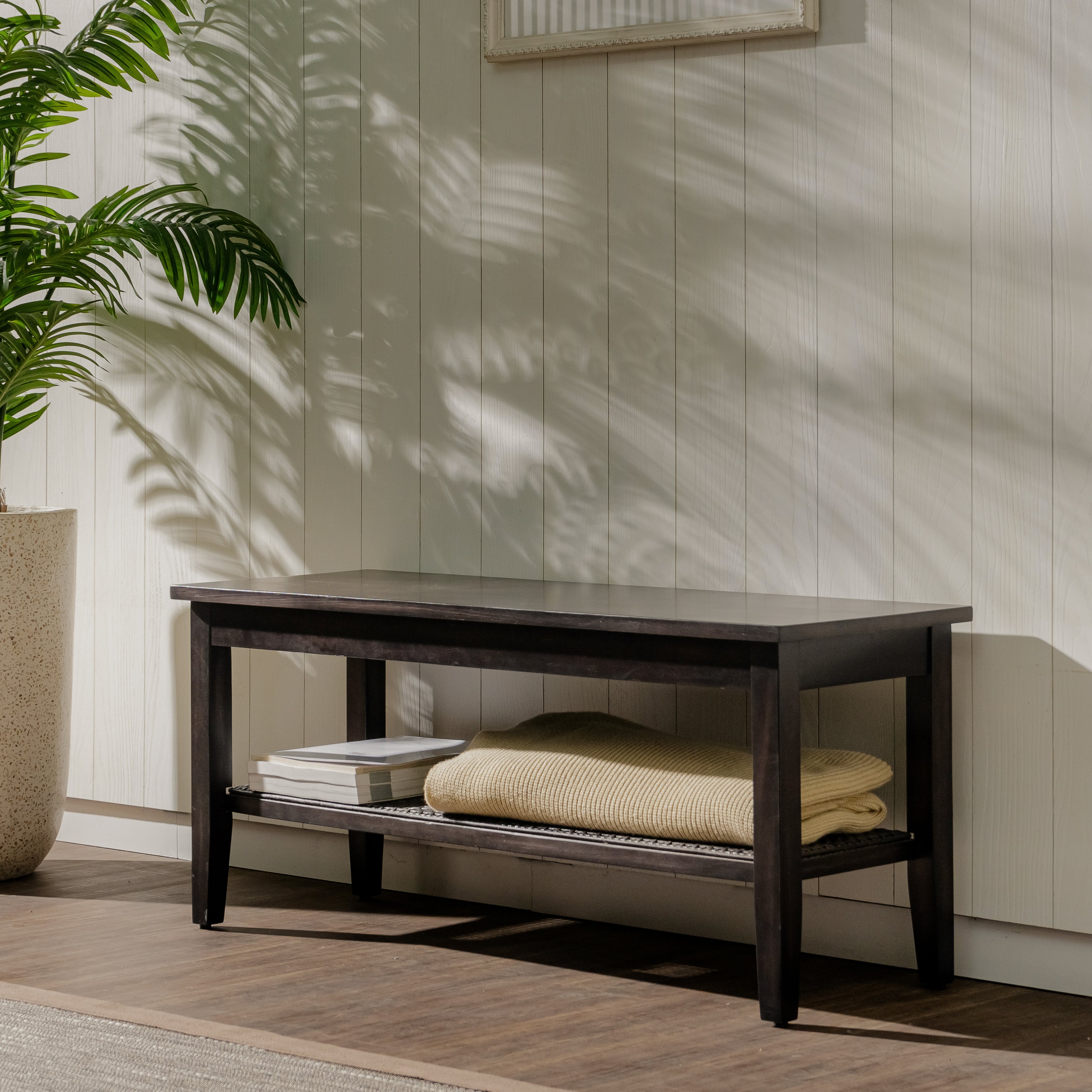 Wooden bench with folded towels against a light wooden paneled wall.