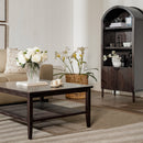 Living room with a coffee table, flowers, and a bookshelf.