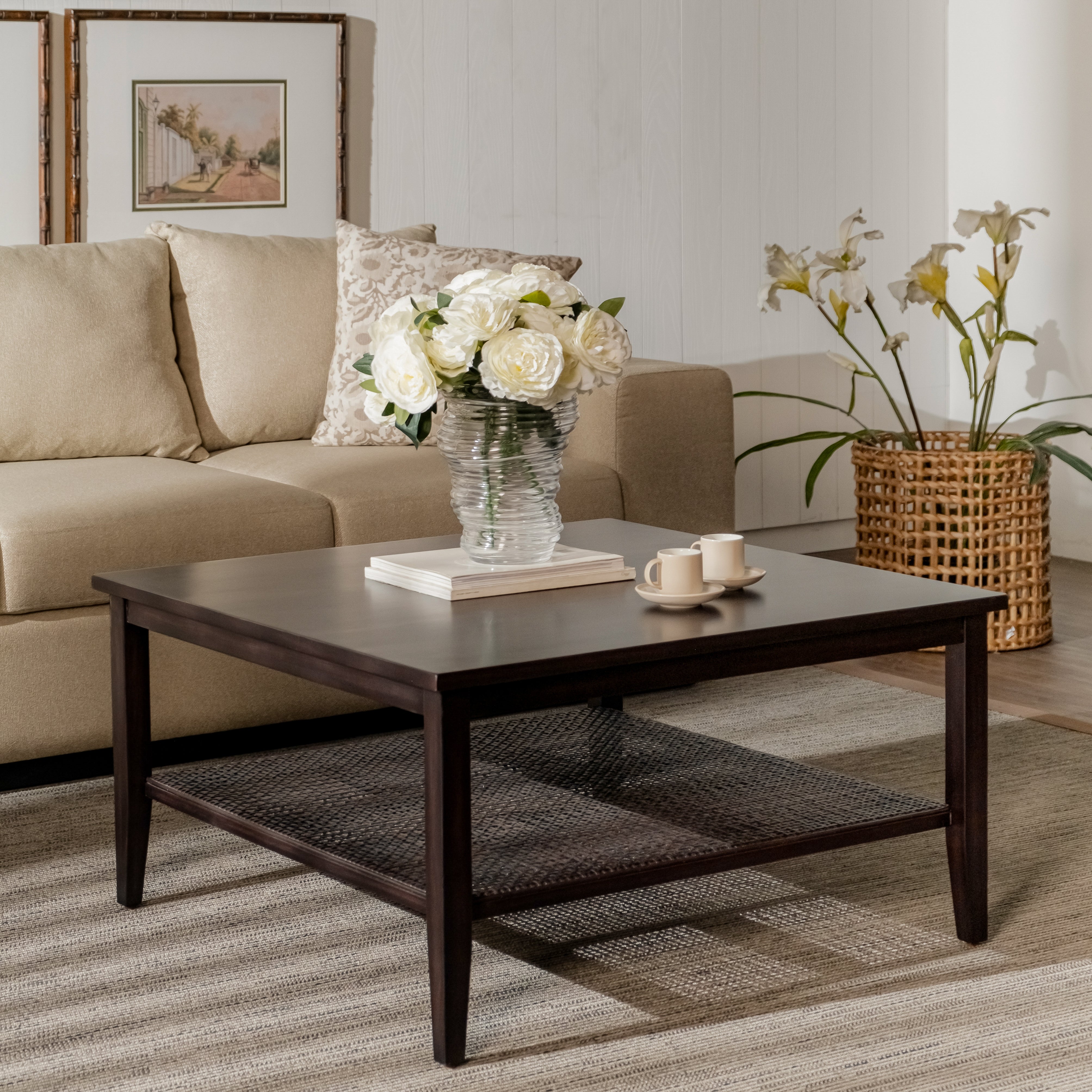 Living room with a dark wooden coffee table, beige sofa, and decorative elements.