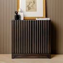 Wooden side table with decorative items against a wall with framed art.