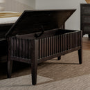 Dark wooden storage bench with open lid in a bedroom setting