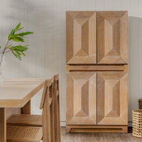 Natural Averi Modular Cabinet  next to a table and chairs in a room with a light-colored wall.