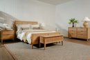 Wooden bedroom furniture set with bed, nightstands, and dresser in a room.