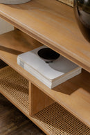 Wooden shelf with a stack of books and a black object on top