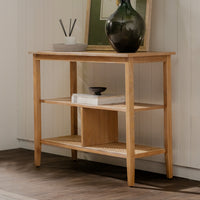 Wooden console table with decorative items against a neutral wall.