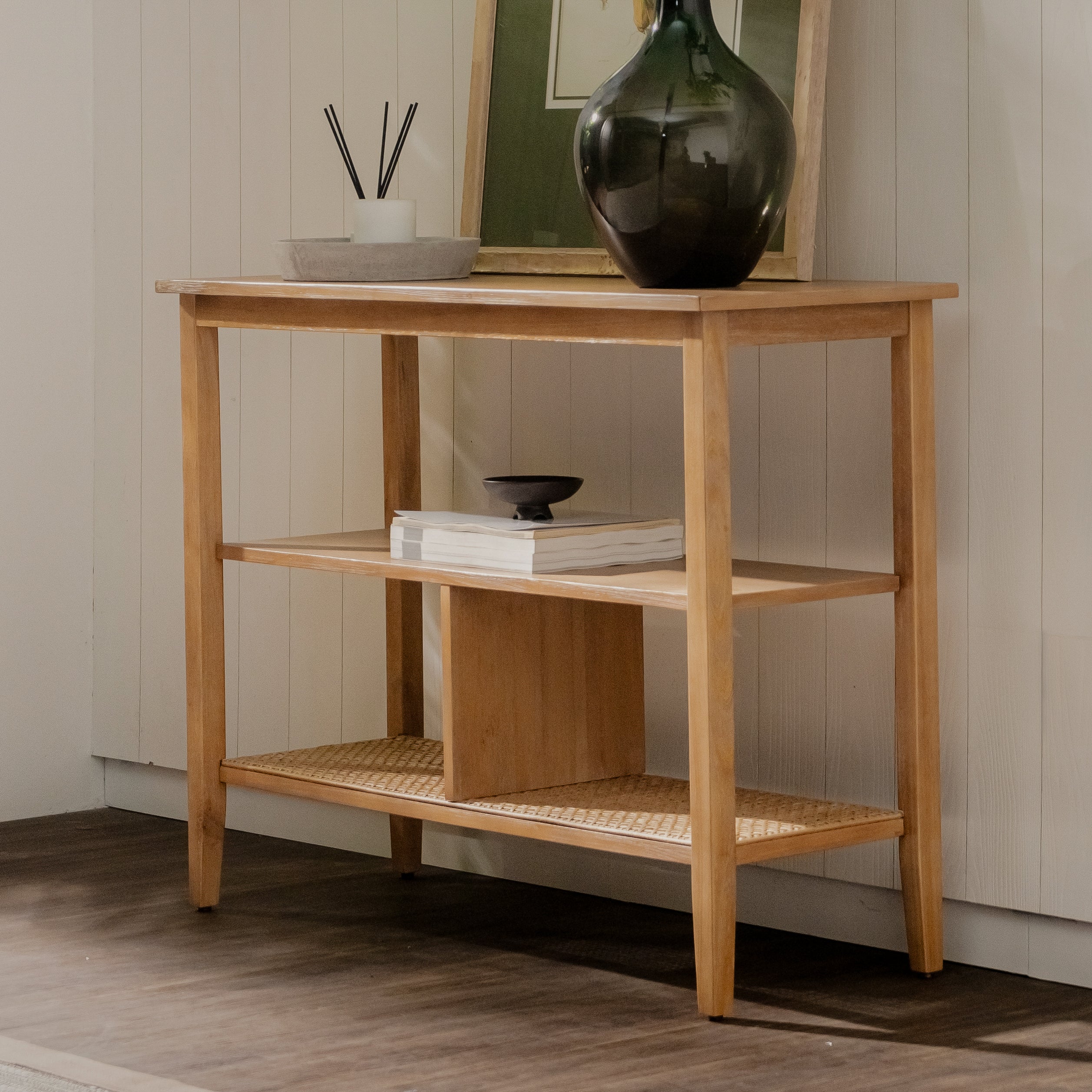 Wooden console table with decorative items against a neutral wall.