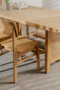 Wooden dining table with chairs on a gray floor
