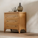 Wooden dresser with wicker drawers against a plain wall