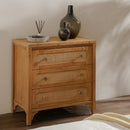 Wooden chest of drawers with wicker-style handles and decorative vases on top.