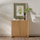 Wooden sideboard with decorative items against a light wooden paneled wall.