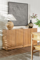 Wooden sideboard with decorative items in a room with a painting and plant.